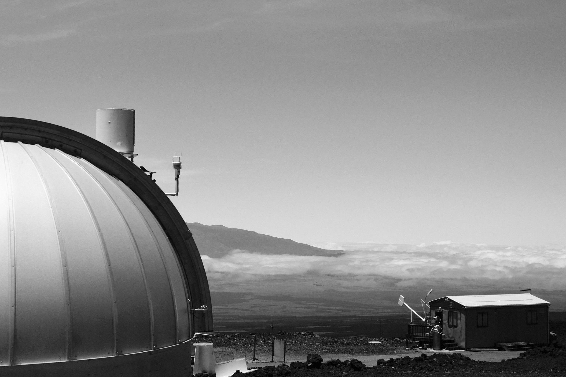 White dome of the Mauna Loa Observatory, with the Mauna Kea mountain in the background